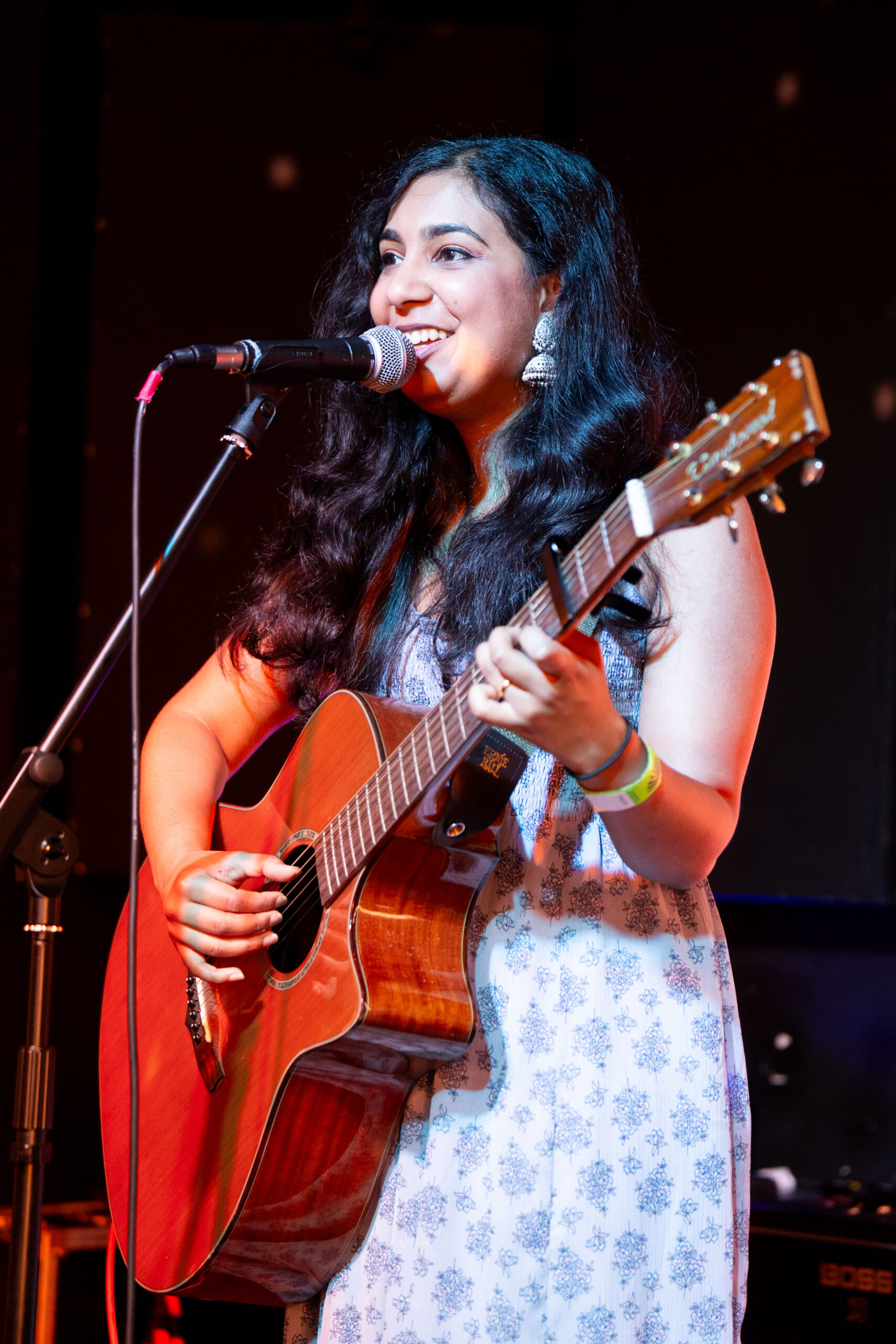A singer with an acoustic guitar performing at The Bread & Roses