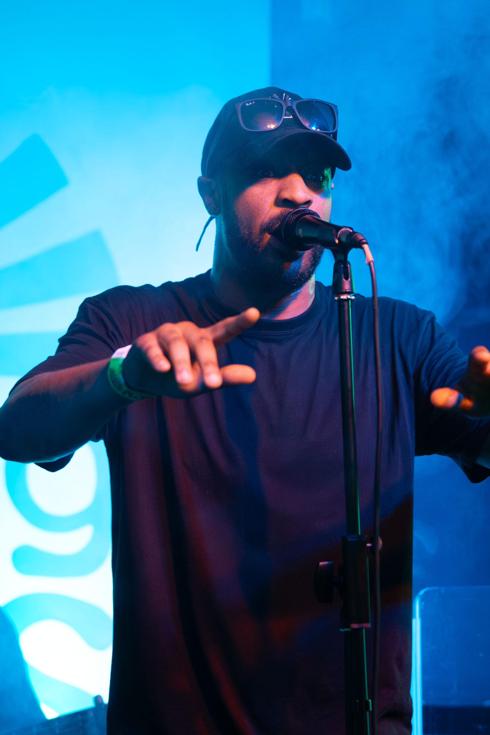 A performer on the microphone under blue stage lighting
